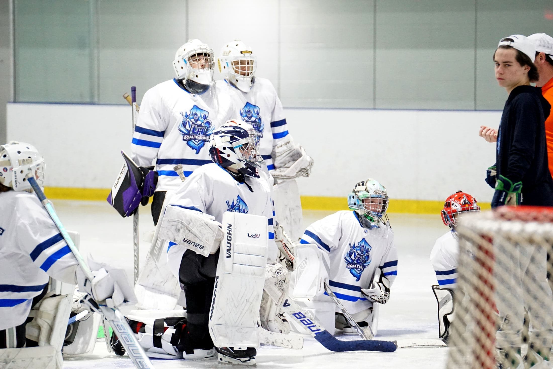 Group of goalies in LH Goaltending jerseys on the ice at camp
