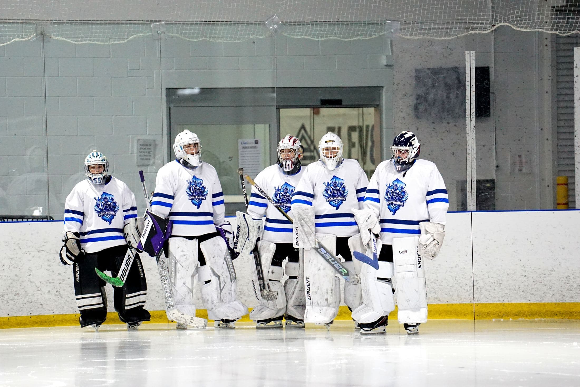 Goalies lined up along the boards during an LH Goaltending lesson
